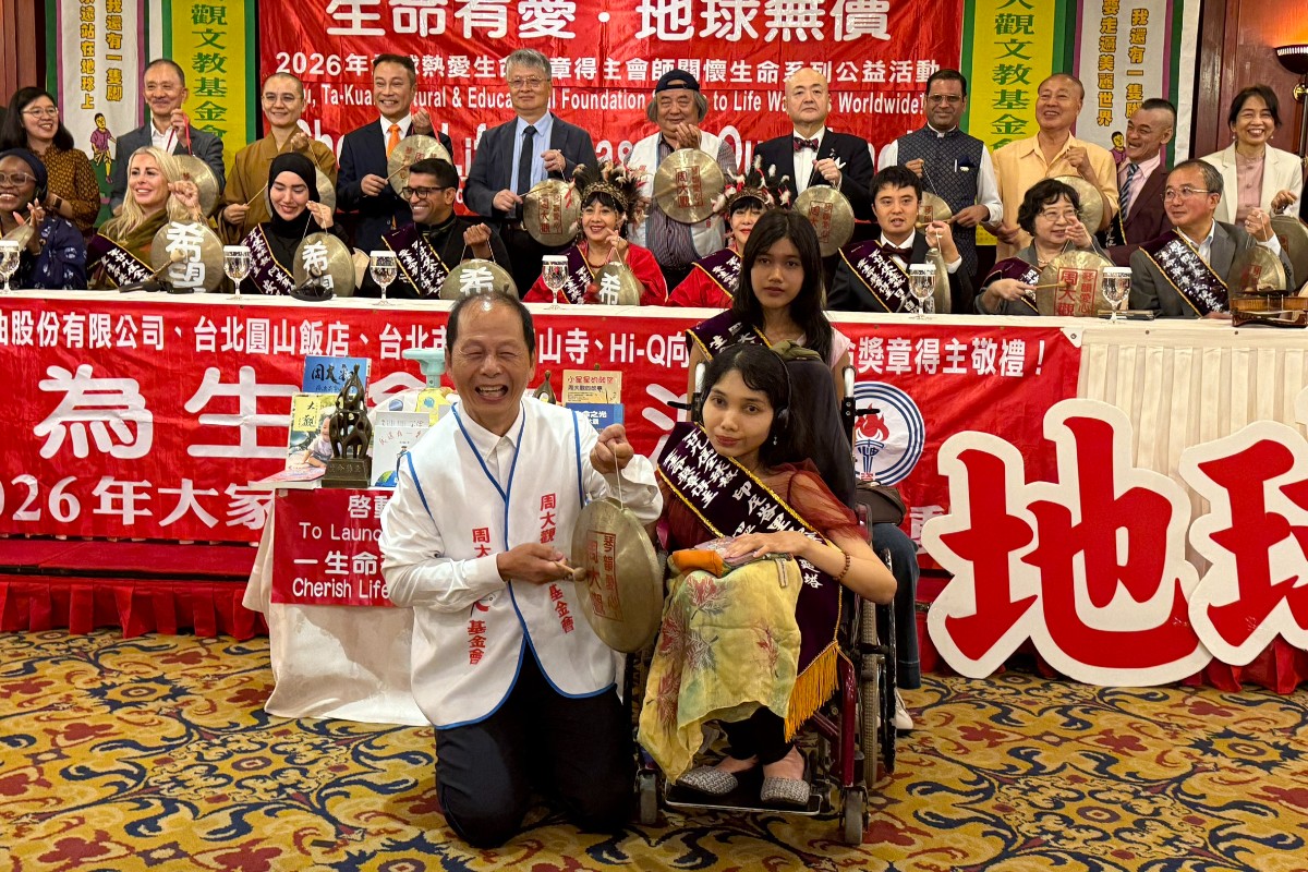 周大觀文教基金會創辦人周進華(左)與全球熱愛生命獎章得獎者、貴賓一同進行敲鑼儀式(記者廖南瑛攝)